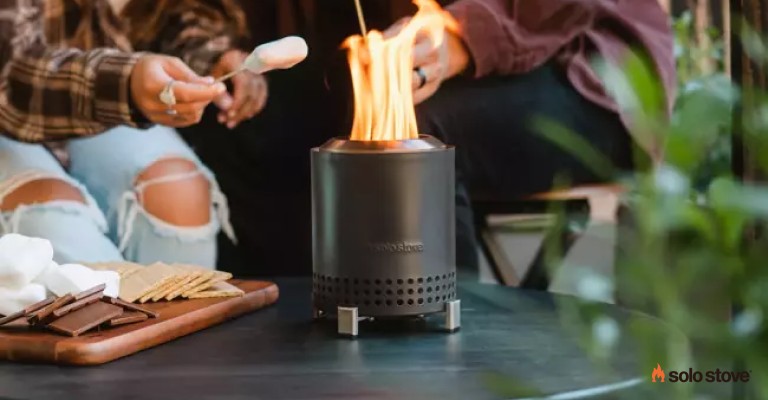 two people using a solo stove mesa