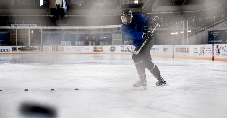 player shooting a puck into the goal