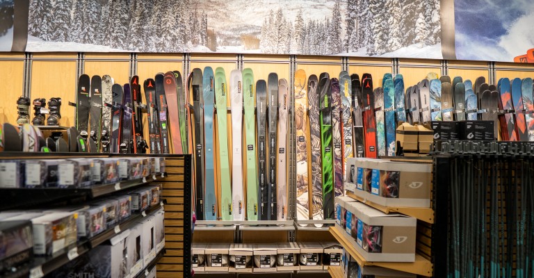 a variety of downhill skis on display at sandy scheels