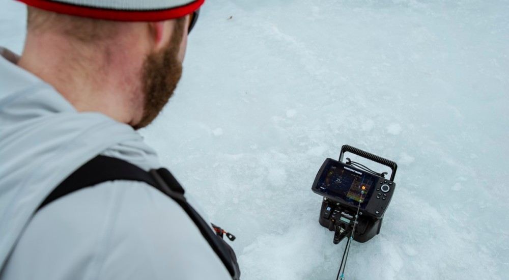 Ice angler fishing with an ice fishing fish finder
