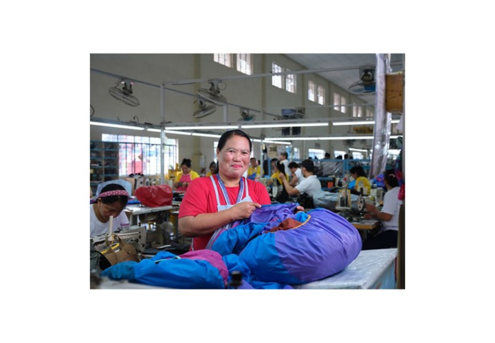 Cotopaxi Phillipines worker sewing fabric in workshop