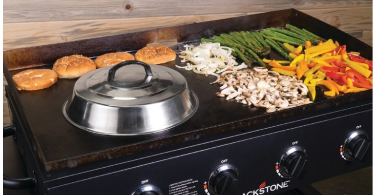 A griddle cooking meat and veggies