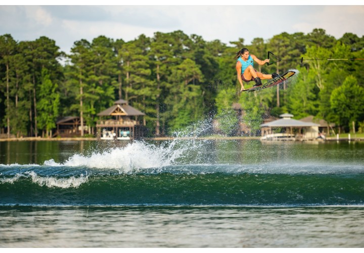 wakeboarder wearing competition life vest jumps over wave