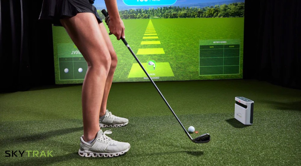 woman golfing using a skytrak monitor and simulation