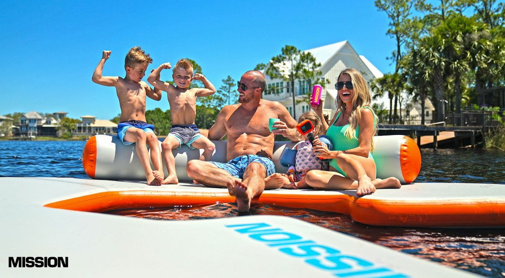 family sitting on a mission inflatable water mat