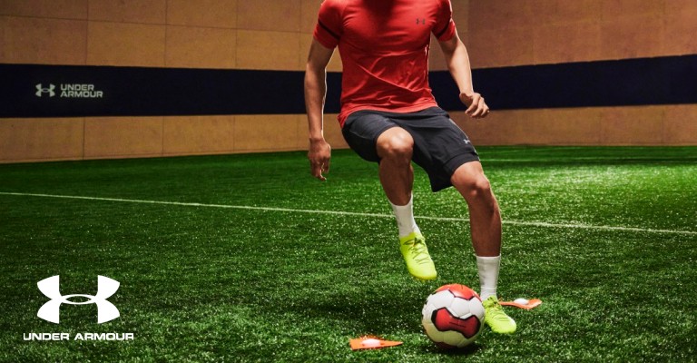 Soccer player playing with a soccer ball on an indoor soccer field 