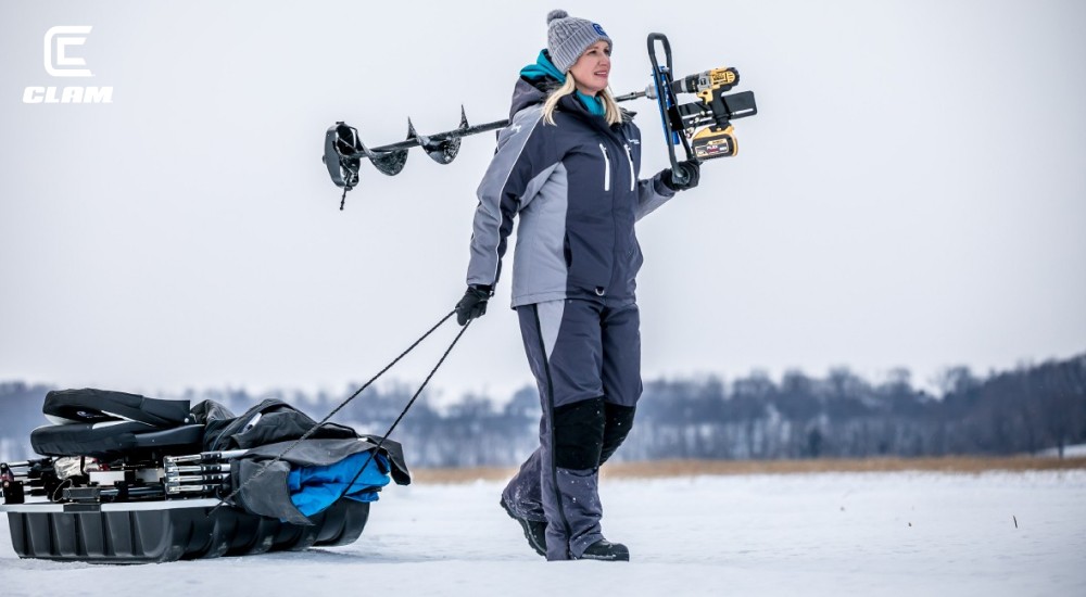 a woman carrying all her ice fishing gear out to her spot