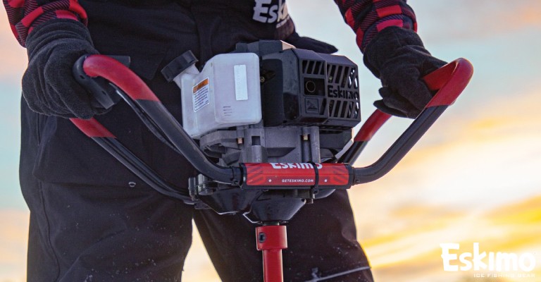 an angler holding the gas powered ice augers