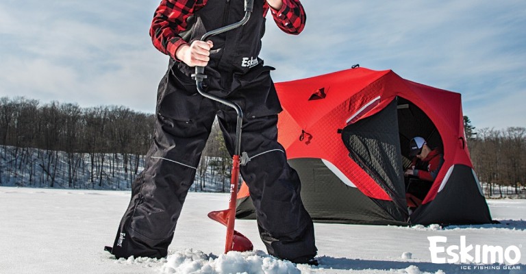 an angler using a hand powered ice auger