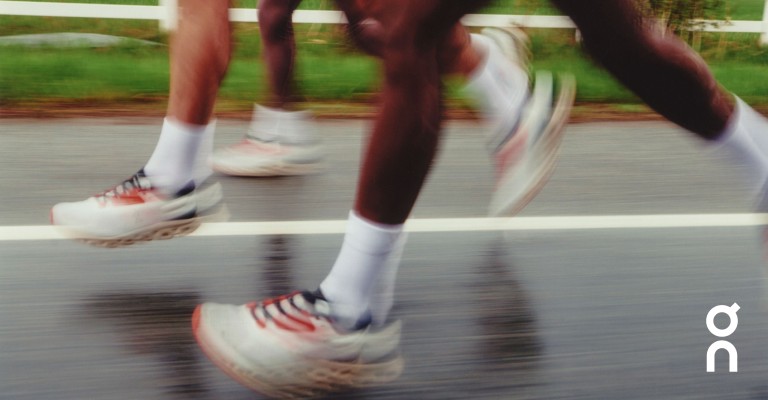blurry image of three runners running Becoming on a road for on cloud