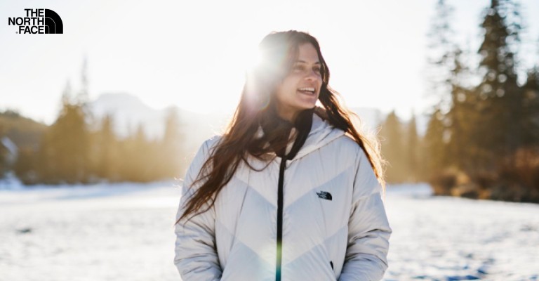 Woman smiling in white North Face puffer jacket