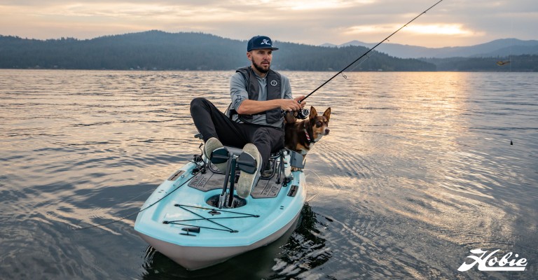 guy kayaking with his dog on a lake