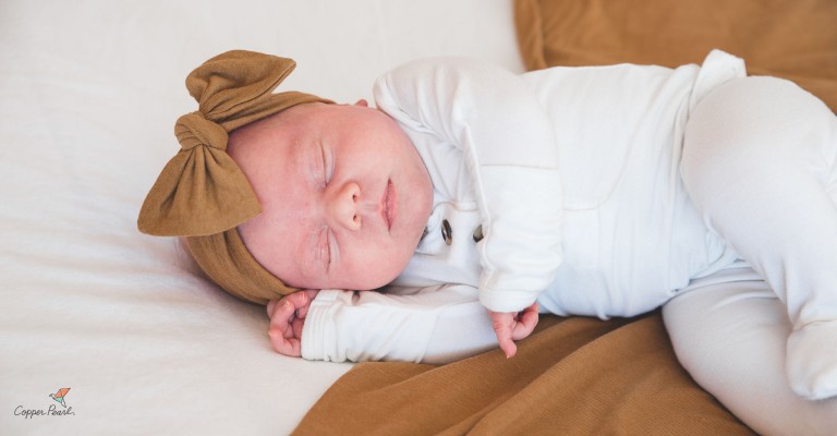 newborn baby sleeping in copper pearl swaddle blanket