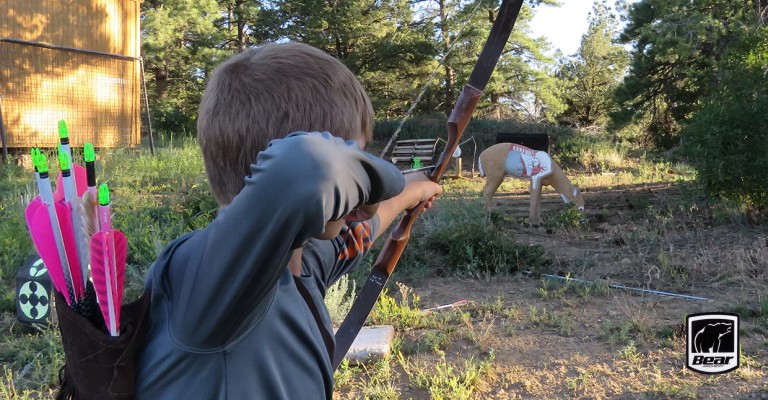 Child shooting a recurve bow at a target