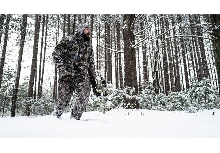 Bow hunter in a snowy forest