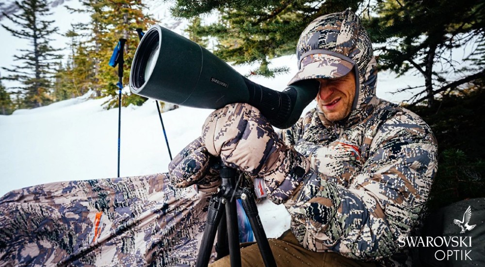 A hunter using a Swarovski spotting scope when winter hunting