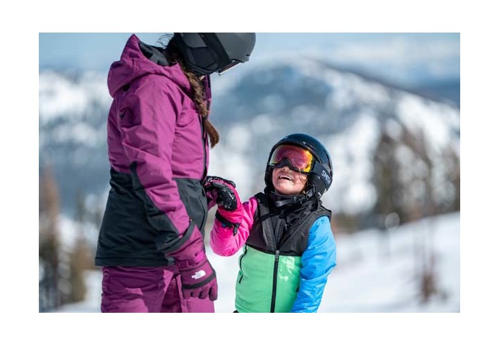 A child and mom out on the mountain skiing. 