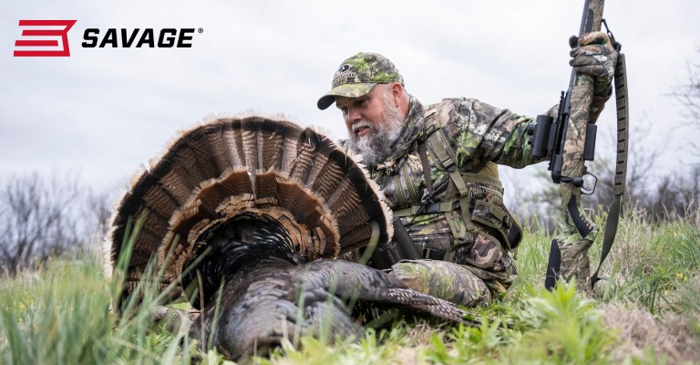 Turkey hunter holding up his turkey after a hunt