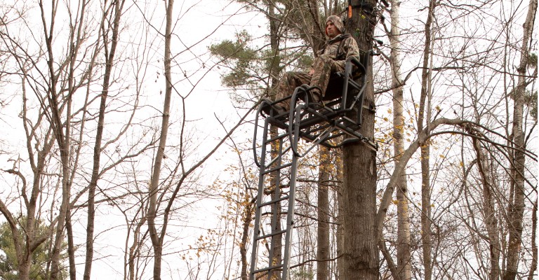Hunter sitting in a ladder treestand