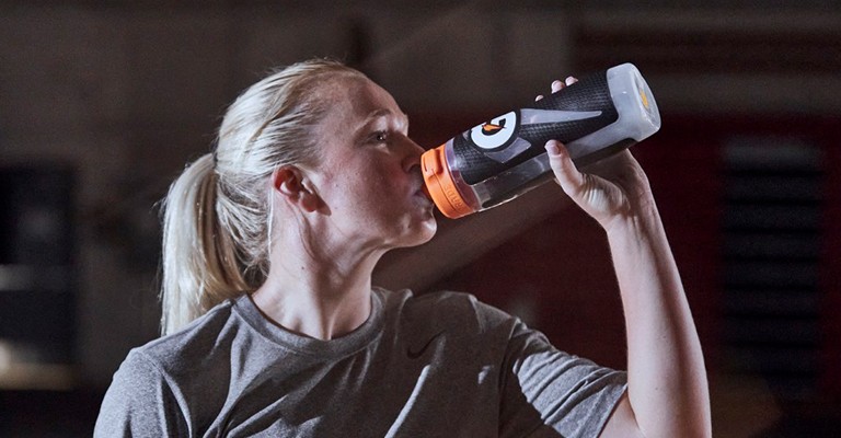a volleyball player drinking from a water bottle