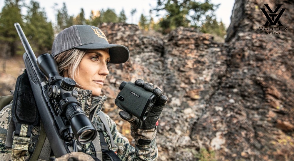 hunter using rangefinder and riflescope