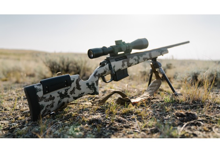 Weatherby Model 307 rifle against prairie background. 