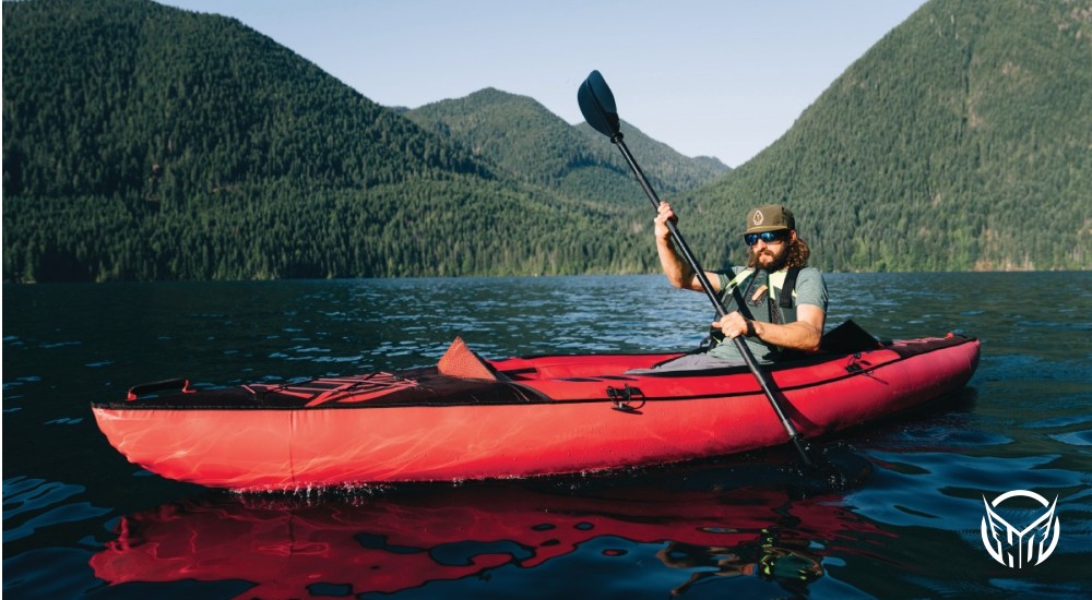 Kayaker in the water near mountains 