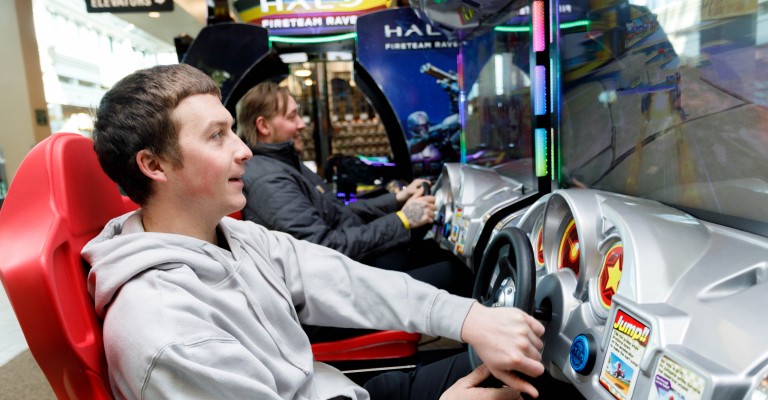 two guys playing an arcade game at mankato scheels