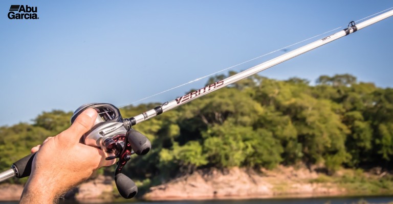 a fisherman holding a baitcasting combo