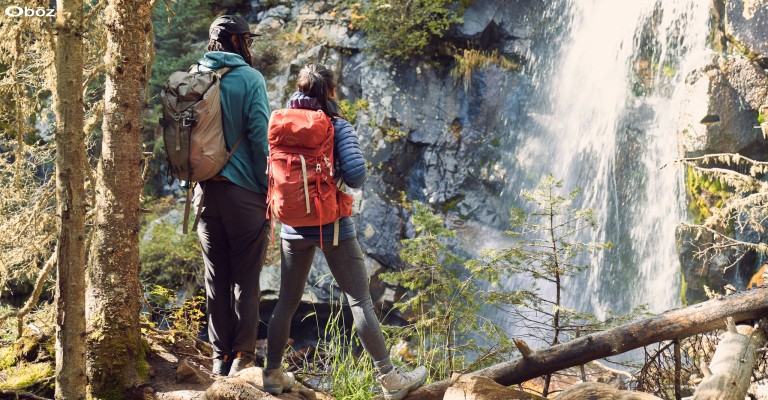 two hikers out hiking and looking at a waterfall