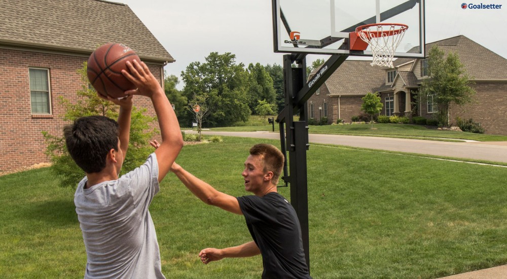 two boys playing basketball in the driveway