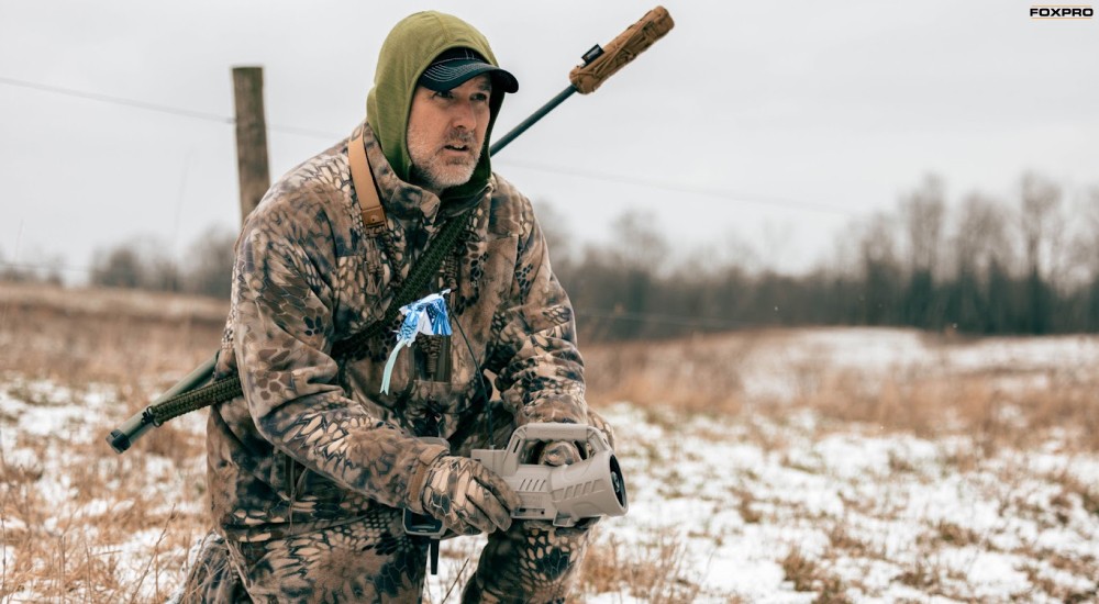 a hunter using a foxpro electronic game call in the field