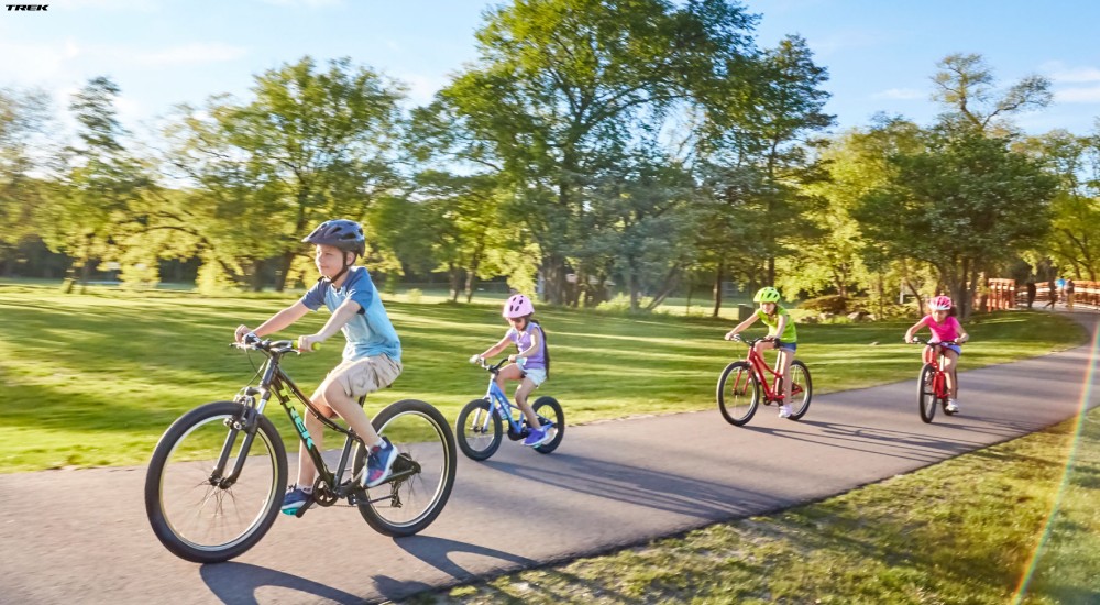 a group of kids riding their trek bikes