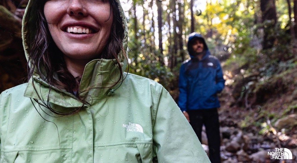 a man and a woman hiking while wearing rain jackets