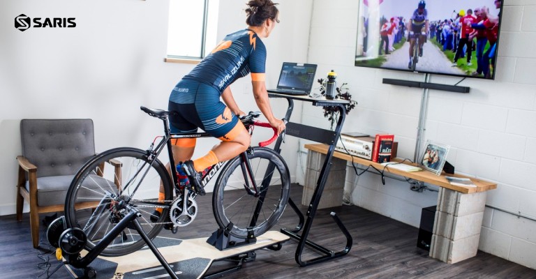 woman using bike trainer accessories to improve her setup