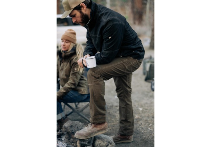 Man standing by fire drinking coffee