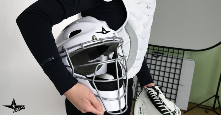 a player holding a catchers helmet