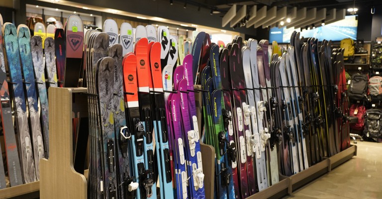 a variety of downhill skis at a scheels store