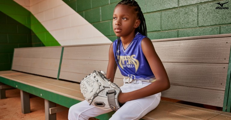 a young softball player holding a softball glove