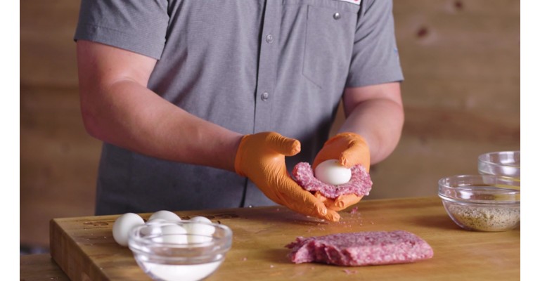 Wrapping boiled egg in sausage