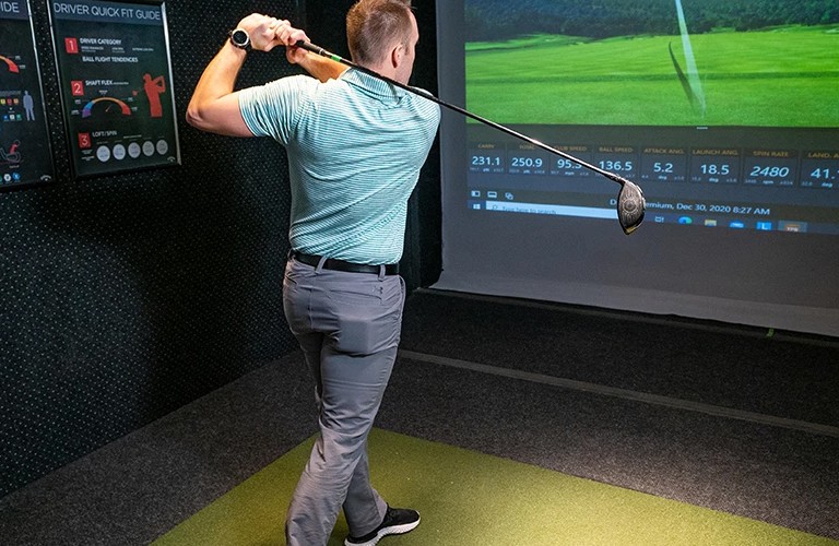A player swinging during a custom golf club fitting