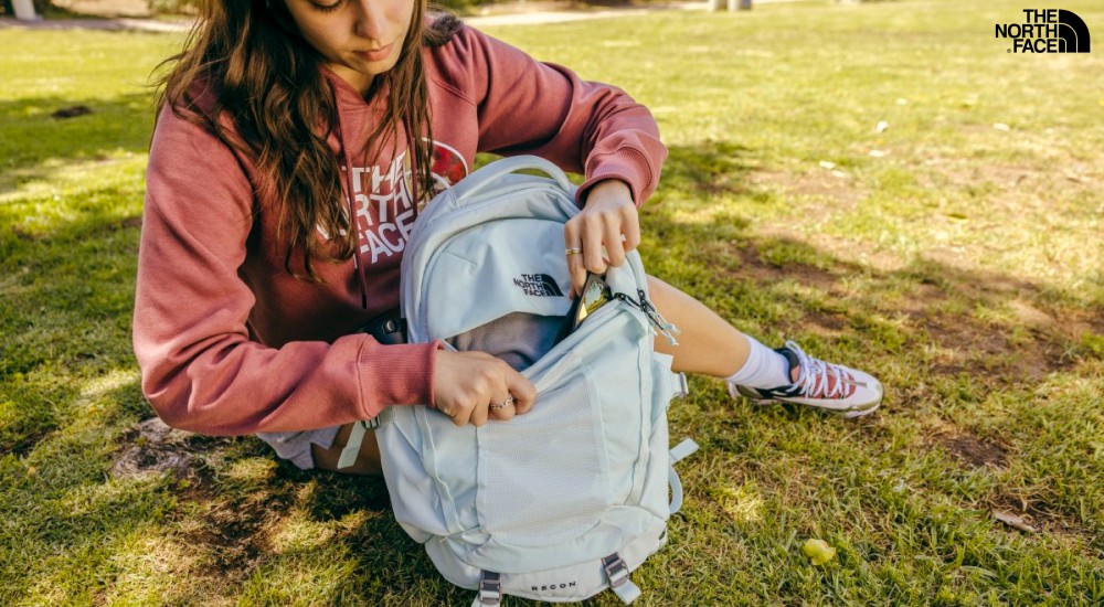 a girl opening a pocket on her backpack