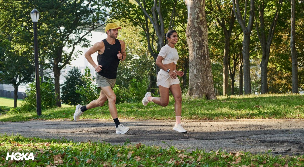two people wearing hoka running shoes out on a run