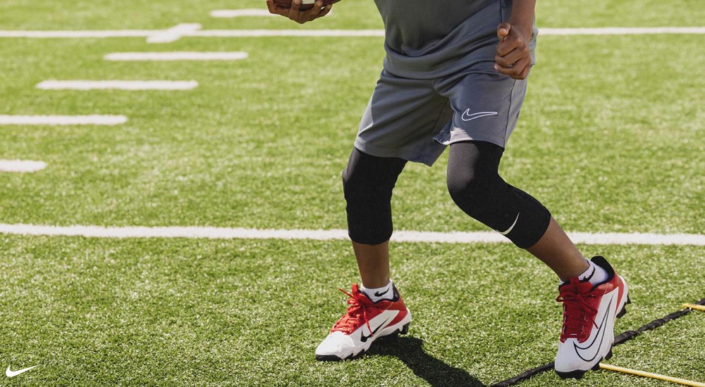 a boy wearing nike football cleats during practice