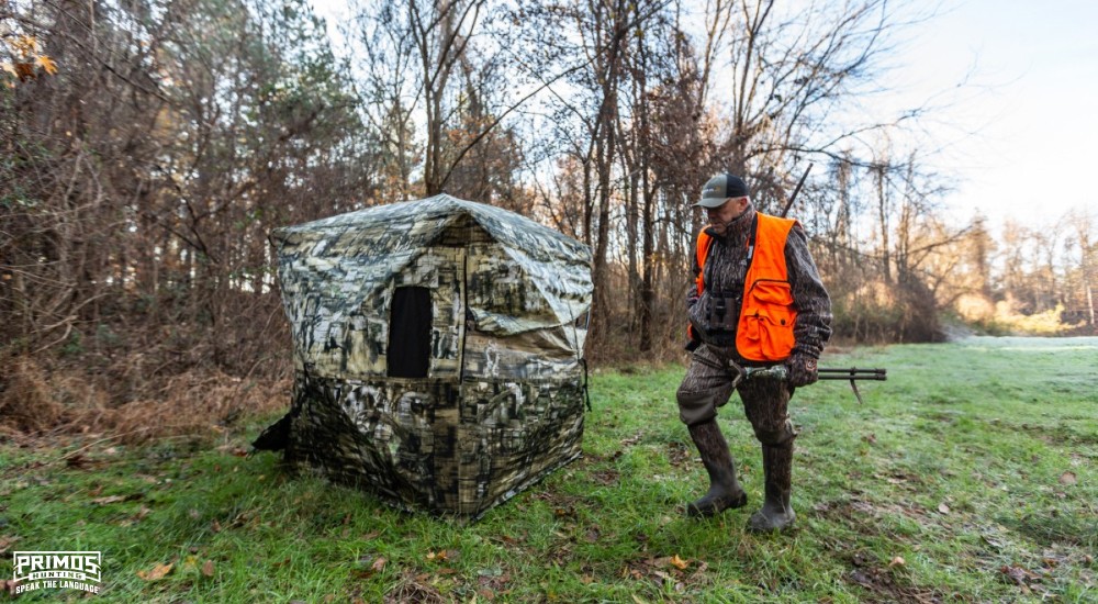 a hunter getting his ground blind set up in the field