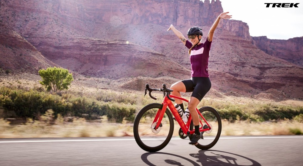 a woman riding her road bike without hands