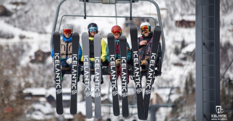 people sitting on a ski lift wearing downhill skis