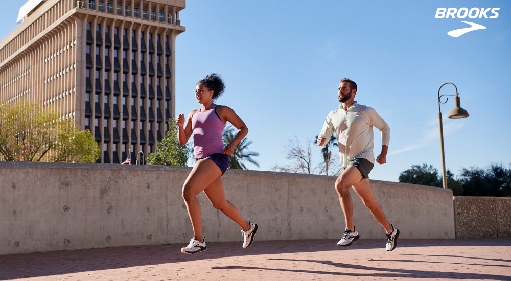 a male and female runners running in the city