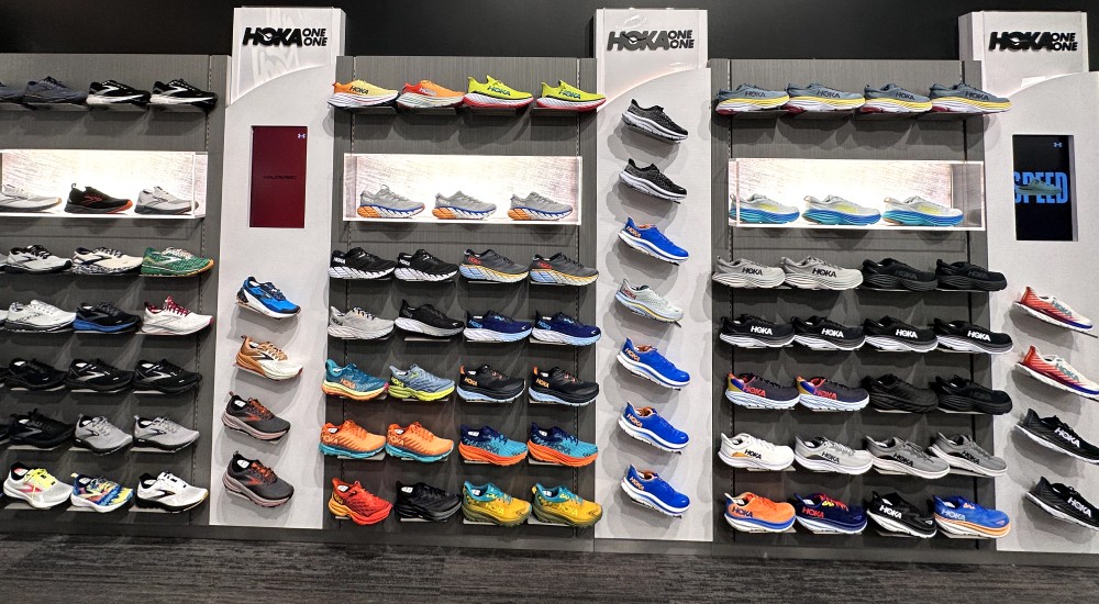 a wall of running shoes within the mens shoe shop at johnstown scheels