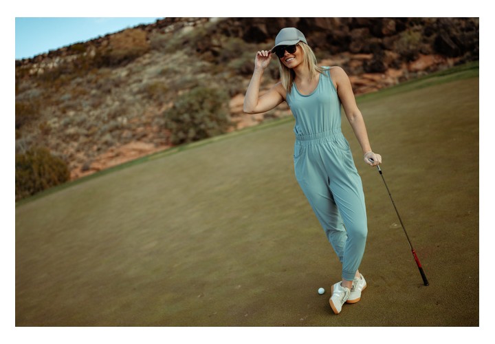 Girl on golf course wearing Kuhl vantage jumpsuit